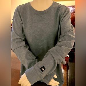 A men's long sleeve denim blue colored North Face sweatshirt